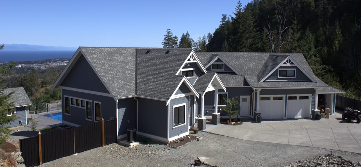 Large gray craftsman home with ocean view and pool