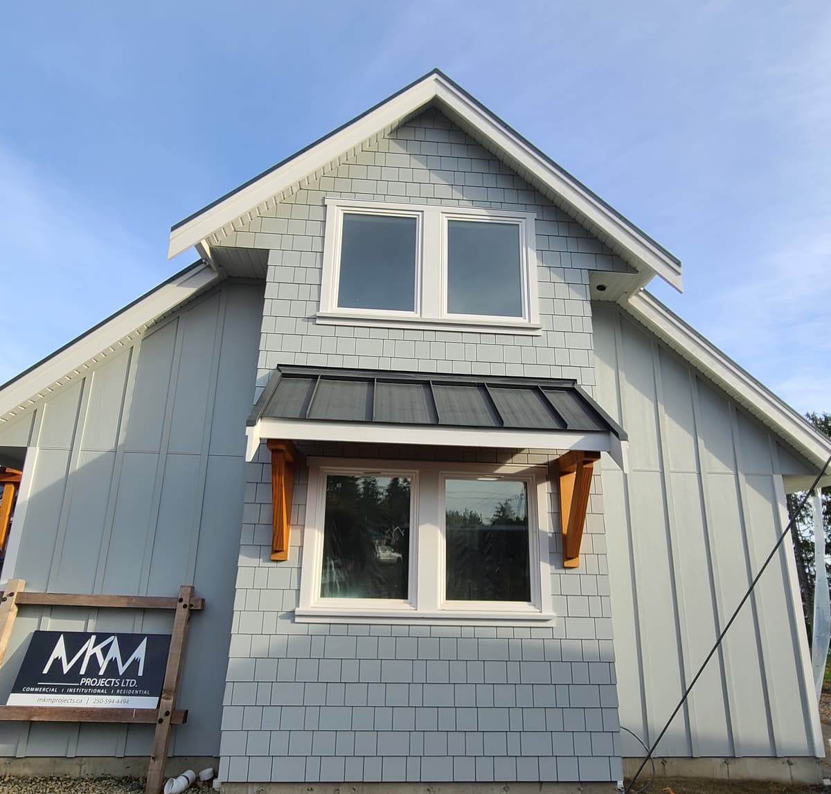Gray Hardie shingle and board siding with cedar bracket accents