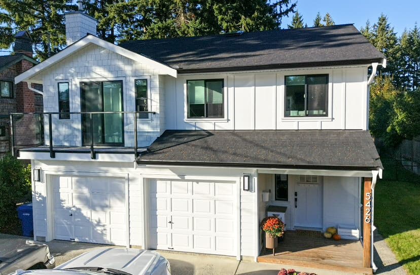 White Hardie board and batten home with glass balcony railing