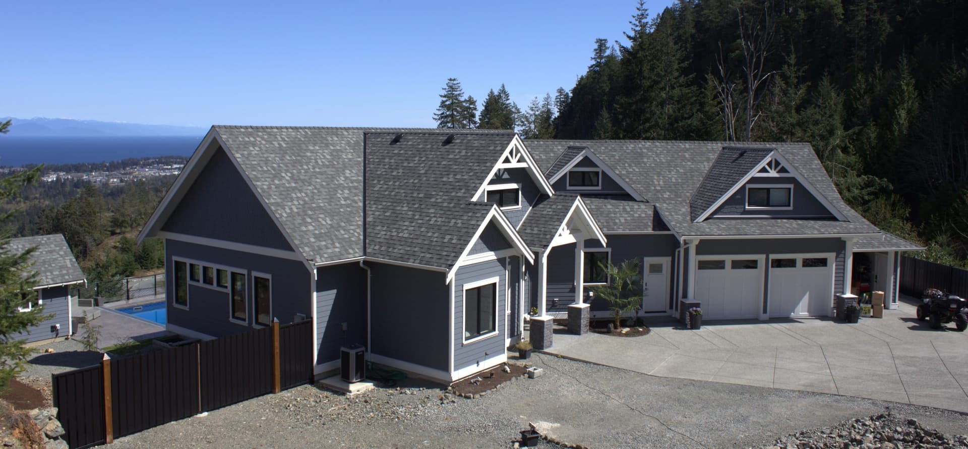 Large gray craftsman home with ocean view and pool