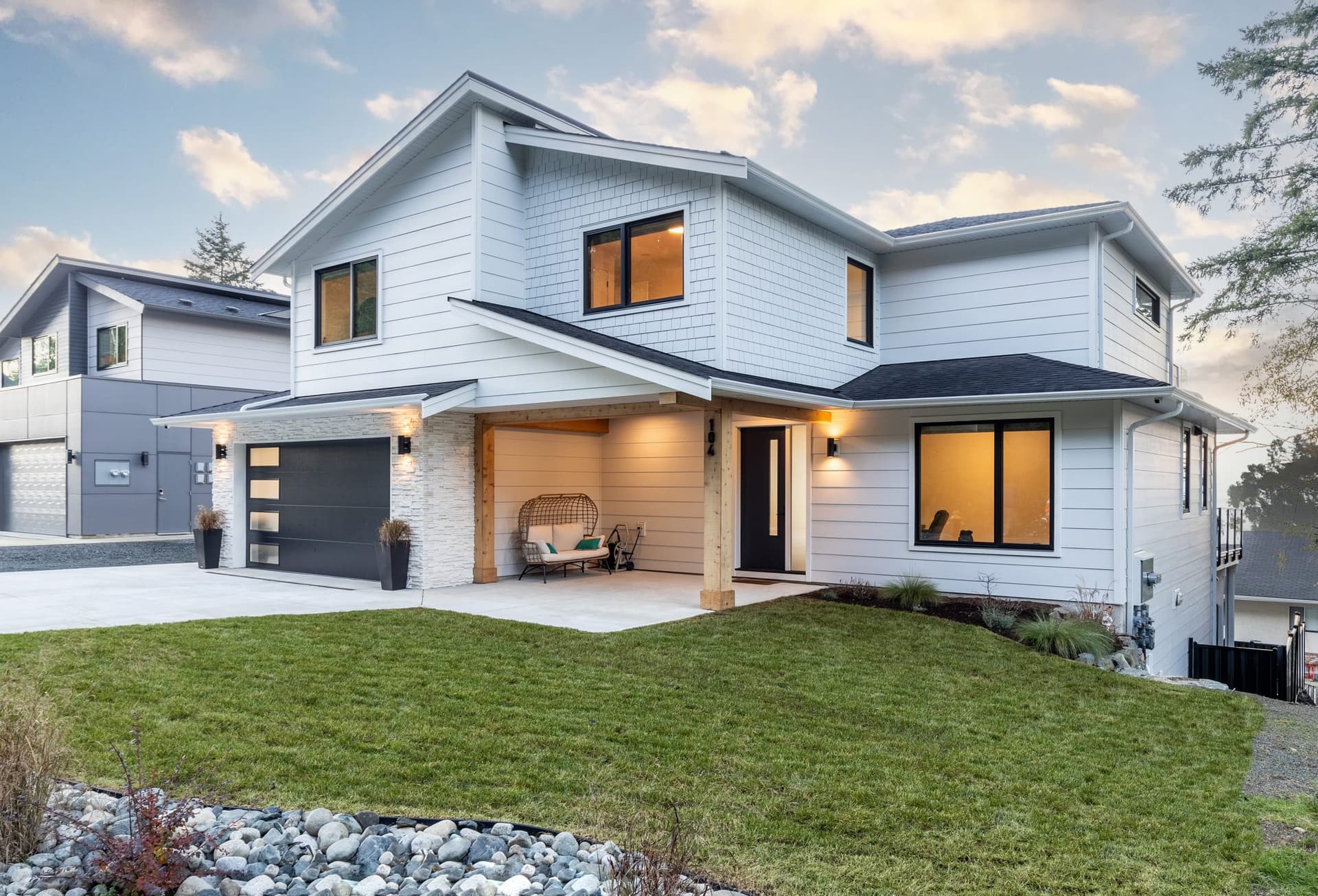 White Hardie lap and shake siding on a two-storey home at dusk with a timber post entry