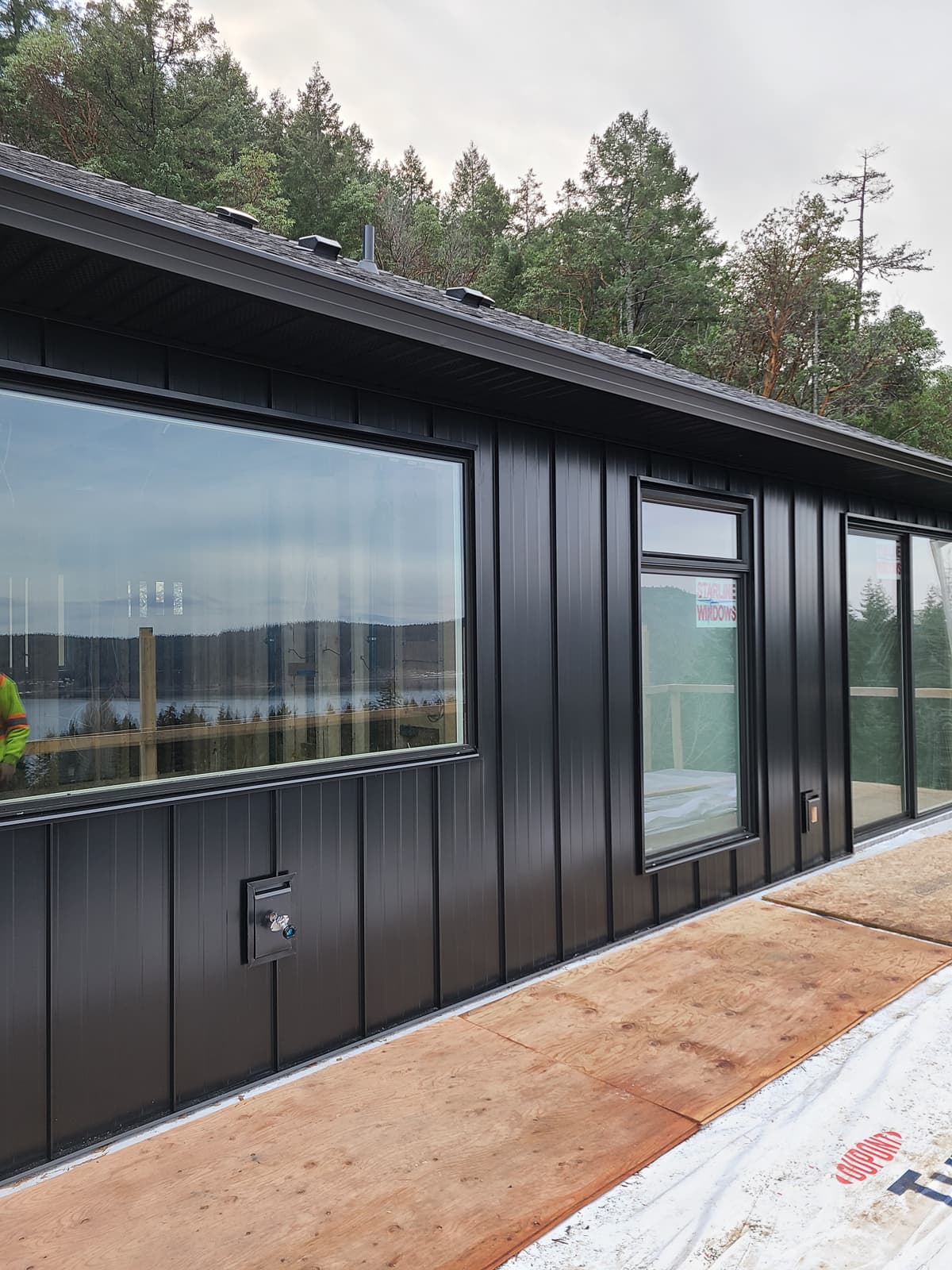 Black metal horizontal siding installation in progress