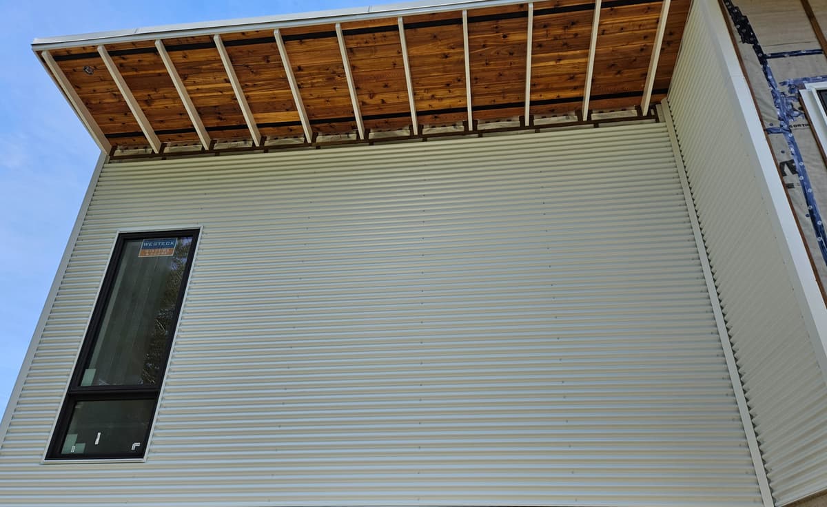 Corrugated metal siding with exposed cedar soffit beams