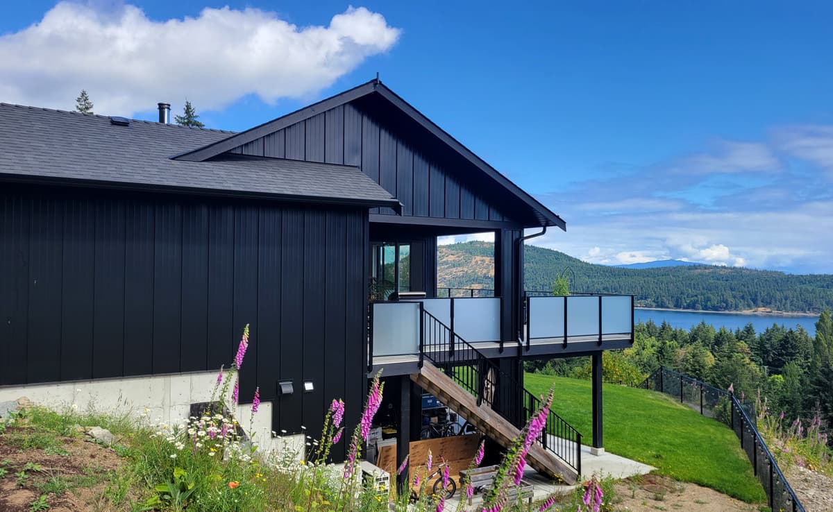 Black metal siding home with ocean and mountain views