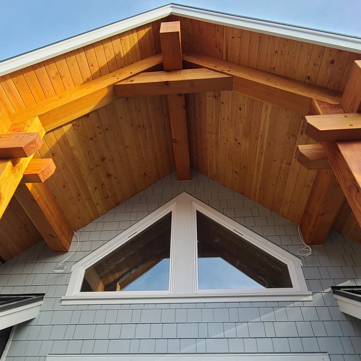 Cedar soffit and timber beam detail on custom home gable